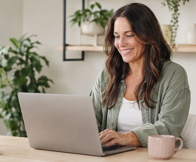 Happy Wellness business owner looking at her laptop